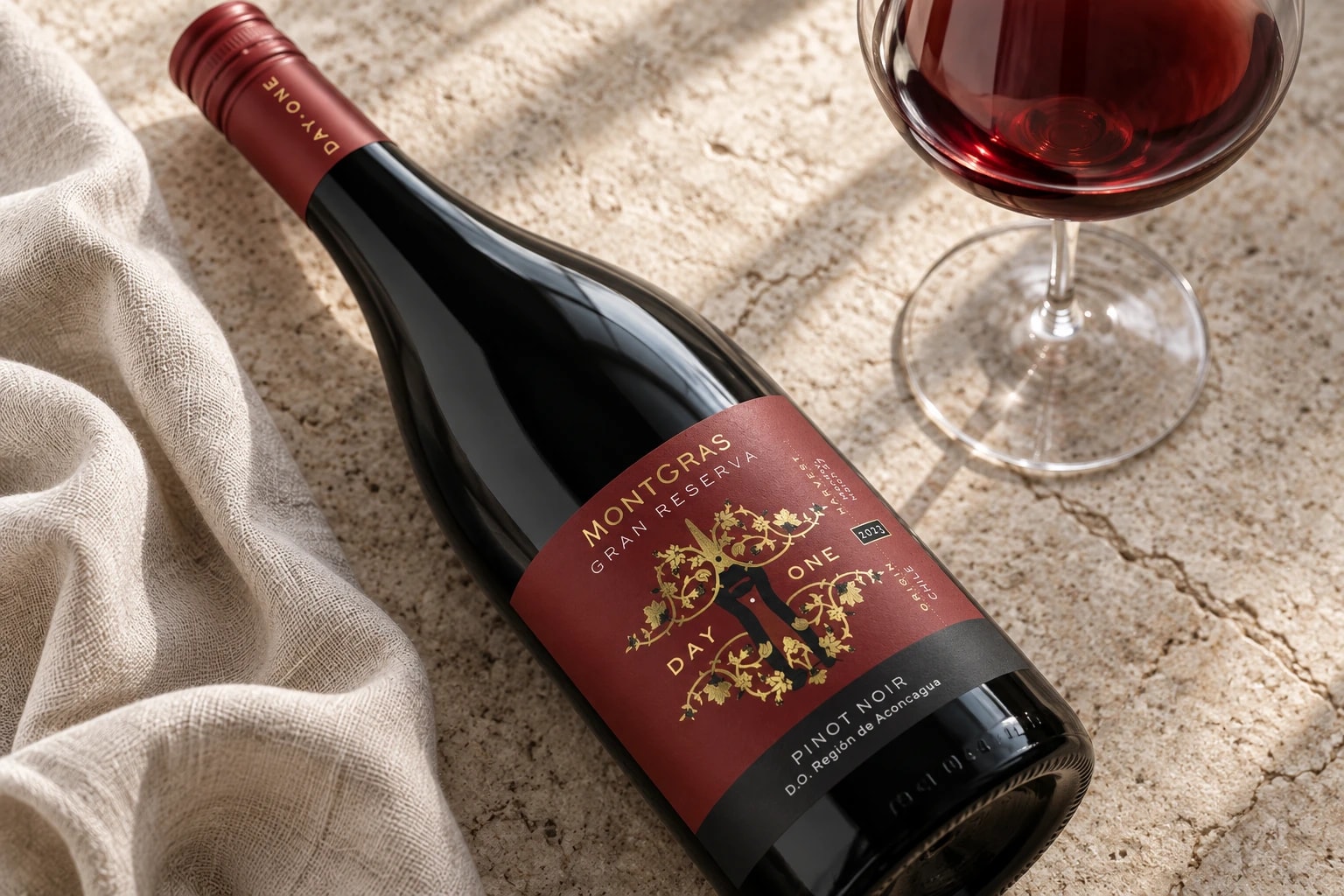 MontGras Day One 2023 Pinot Noir resting on limestone beside a glass of ruby red wine
