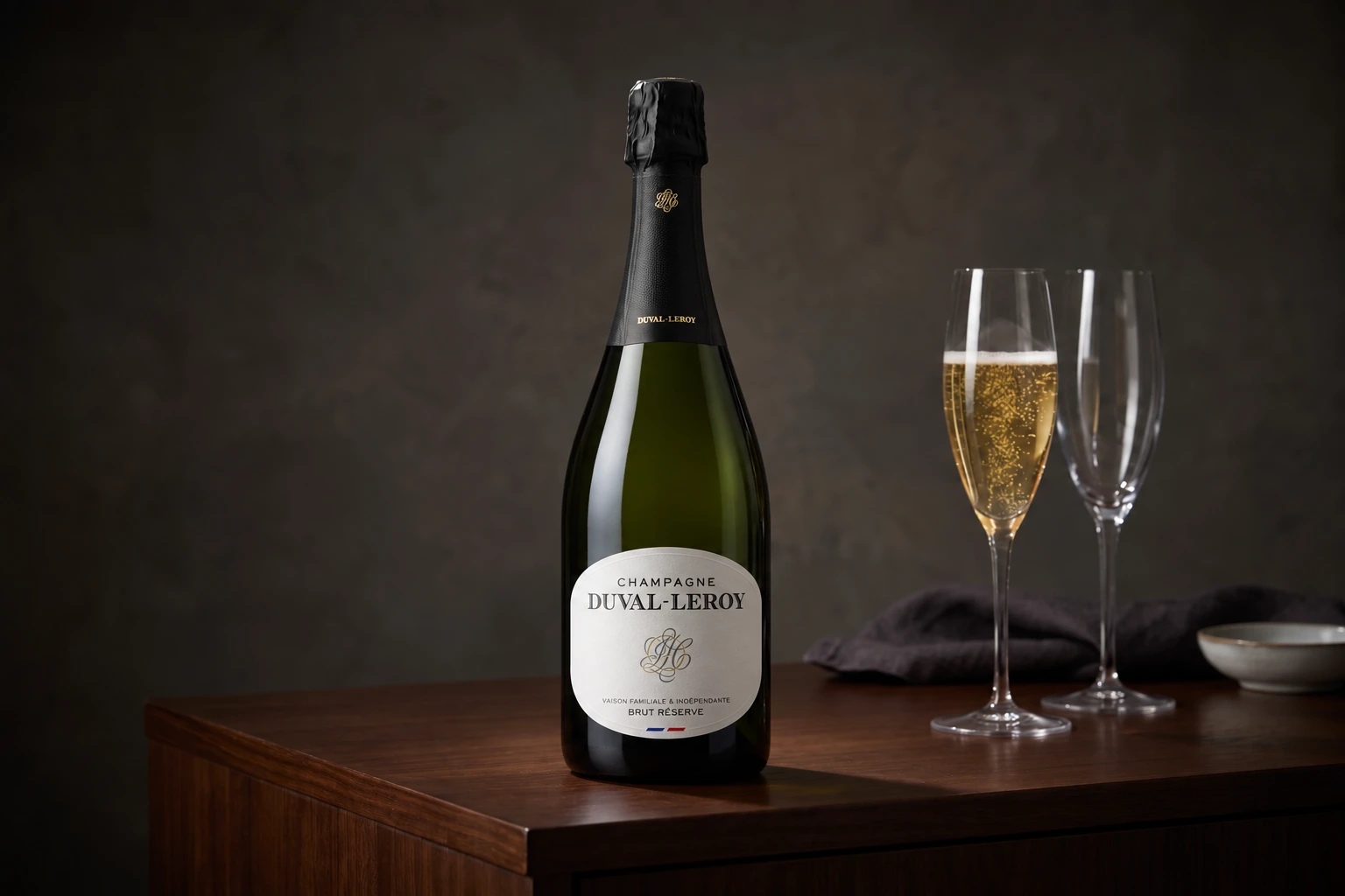 Duval-Leroy Brut Réserve with two champagne glasses on a dark wooden console